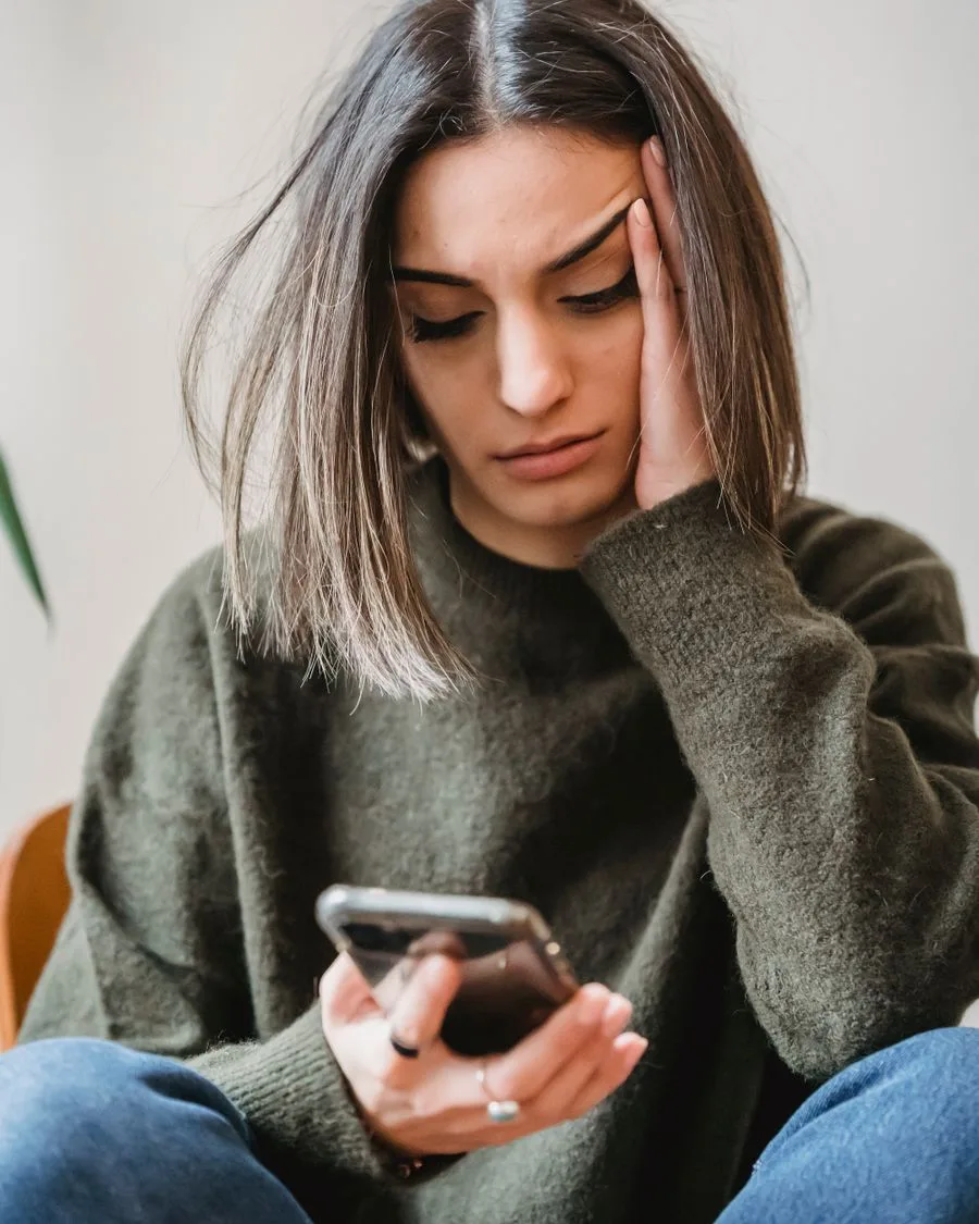 Una mujer preocupada mirando su smartphone